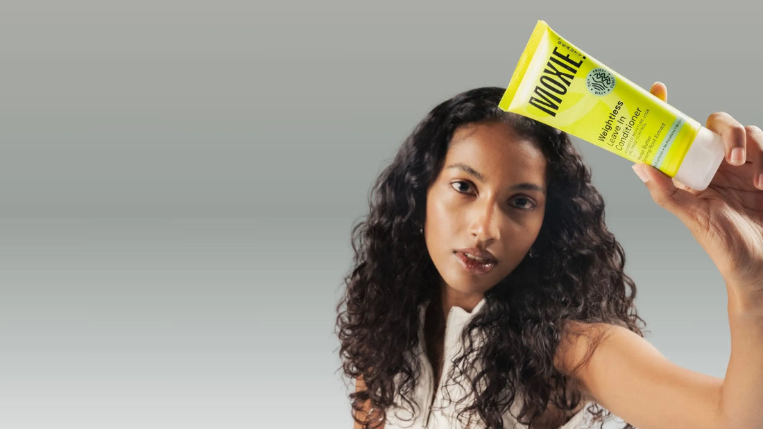 Woman applying leave-in conditioner to her hair for a smooth, shiny finish and healthy locks.